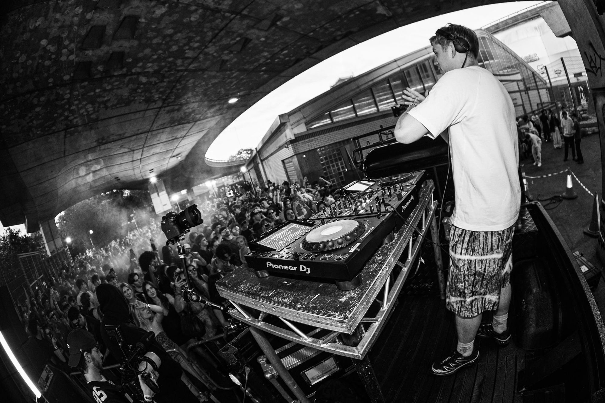 A DJ plays from a Land Rover Defender to a packed crowd under the Westway